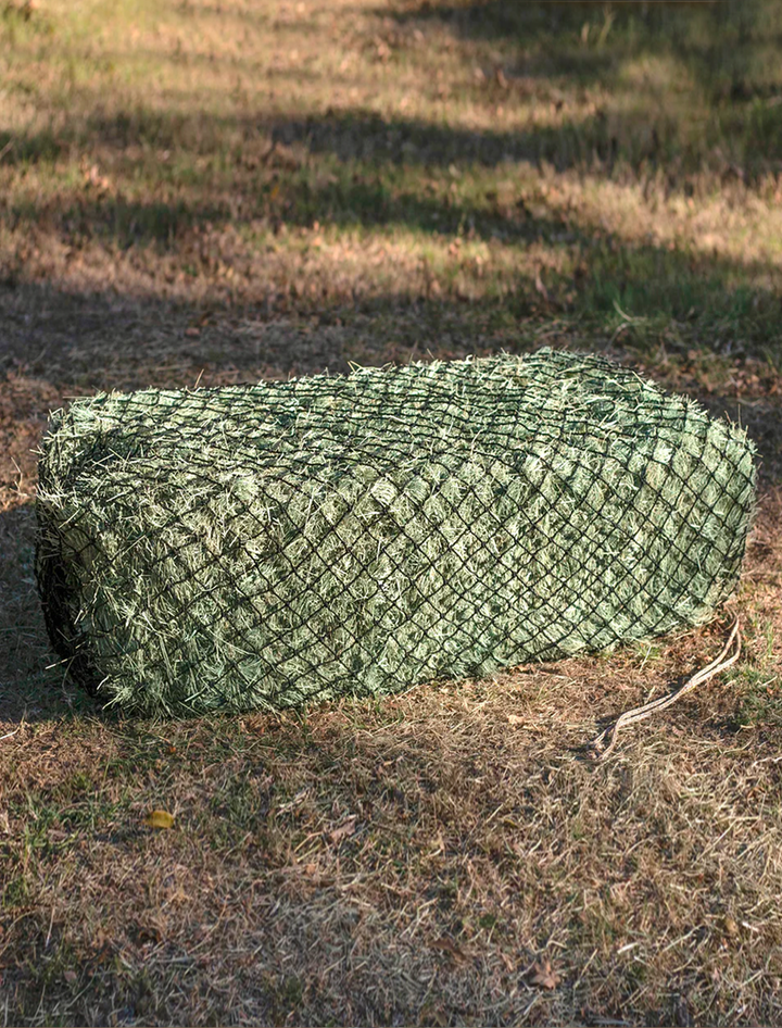 3-string West Coast small hay bale secured in a Hay Chix slow-feed hay net, designed to reduce waste and regulate hay consumption for horses.
